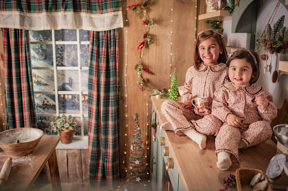 Dos hermanas en pijama con una taza de chocolate.