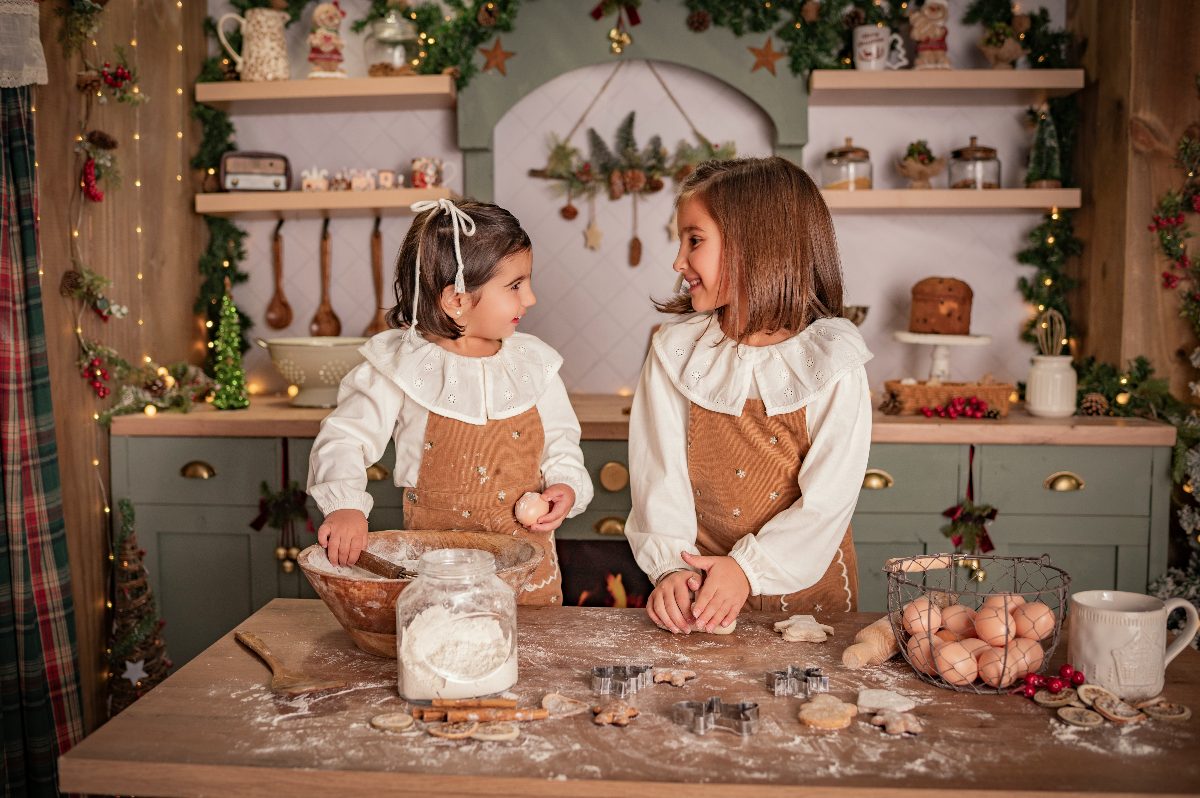 Dos hermanas se miran mientras preparan galletas.