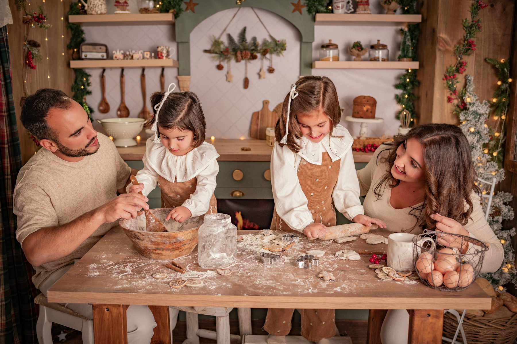 Una familia prepara galletas en la cocina navideña del estudio.